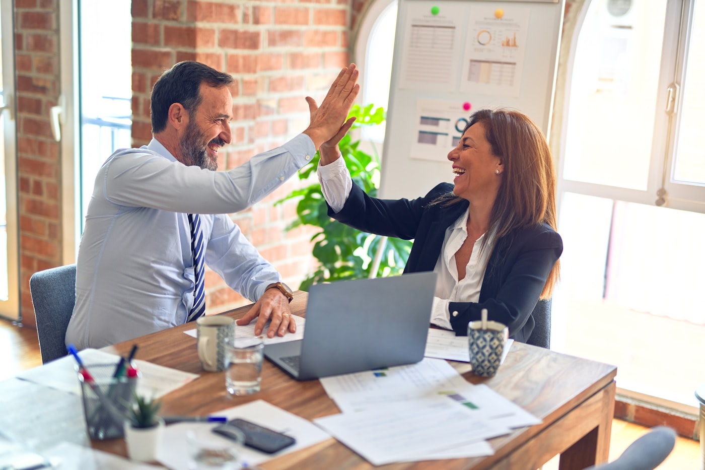 An agent and a happy seller celebrating good news together